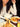 Person eating noodles with a bowl of soup and a plate of rice on a table.