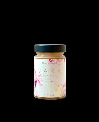 Jar of JARA honey with flowers in the background