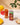 Can of Rishi Hibiscus drink with a glass of the drink on a table with mangoes and crackers.
