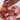 Hand placing prosciutto onto a pizza with tomato sauce and mozzarella cheese.