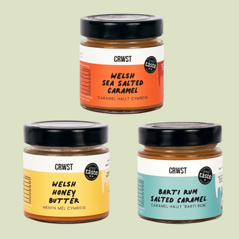 Three jars of different flavors with colorful labels on a light green background