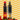 Two bottles of Hillfarm rapeseed oil with chili peppers and garlic on a wavy patterned background.
