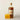 Bottle of Muush drink with a glass of orange juice on a light background