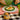 Person eating a meal with a can of Punch on a checkered tablecloth