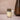 Glass of layered drink with a candle and vase on a neutral background