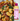 A bottle of Toss Dressing Sweet Tahini Chick sauce placed next to a close-up photo of cooked gnocchi pasta with spinach, sunflower butter, and parmesan cheese.