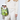 A model in a cream-colored knit cardigan and matching trousers holds a clear tote bag filled with green Hugo Boss tubes, a cucumber, and limes. The model is holding a white smartphone and sunglasses.