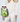 A model in a cream-colored knit cardigan and matching trousers holds a clear tote bag filled with green Hugo Boss tubes, a cucumber, and limes. The model is holding a white smartphone and sunglasses.